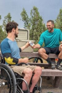 Zwei Männer picknicken auf einer Bank