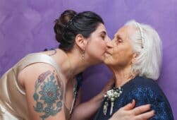 Junge Frau gibt alter Frau einen Kuss auf die Wange