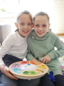 Emma, ein Mädchen mit Behinderung mit ihrer Schwester