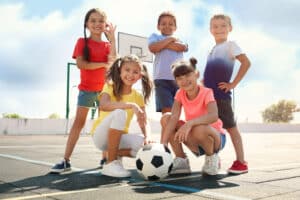 Kinder auf einem Basketballplatz spielen Ball