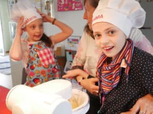 Emma und Marie mit Kochmütze beim Backen