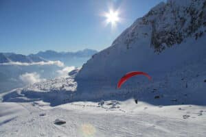 Paraglider mit Handicap vor alpiner Schneelandschaft