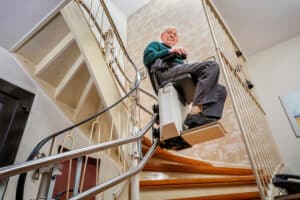 älterer Herr auf einem Treppenlift