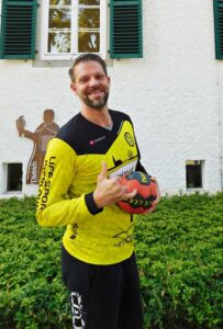 Mann mit Fingerprothese und Ball in der Hand