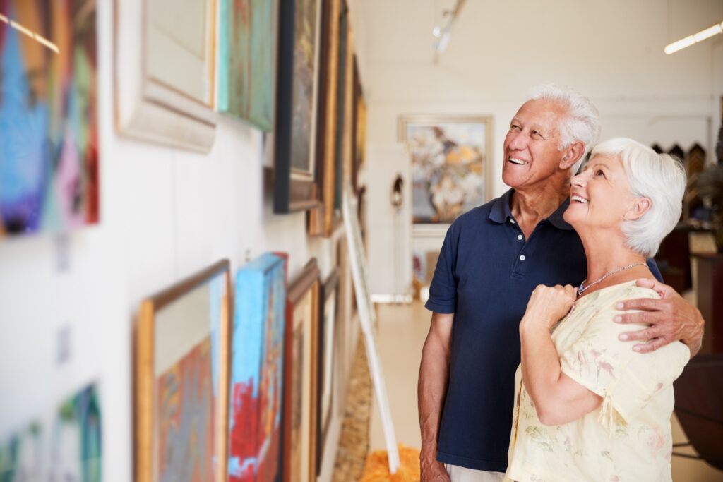 Paar der Generation Plus betrachtet Kunstwerke in einer Galerie