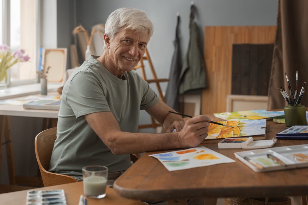&Auml;lterer Mann malt in einem hellen Atelier